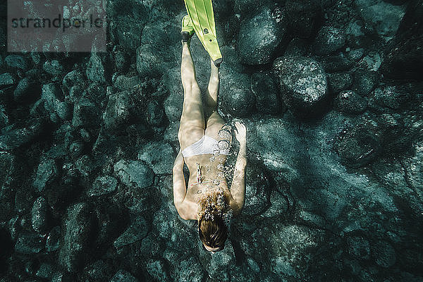 Hochwinkelaufnahme einer Frau beim Unterwasser-Tauchen