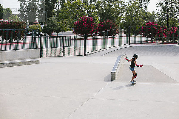 Hochwinkelaufnahme eines Mädchens beim Skateboarden im Park