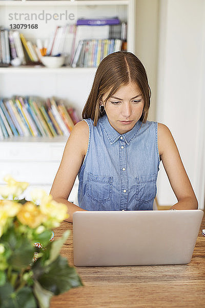 Schöne Frau benutzt Laptop zu Hause