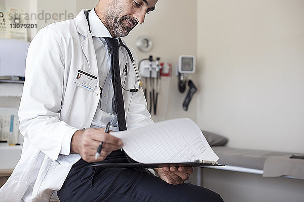 Arzt bereitet Berichte vor  während er im Krankenhaus sitzt