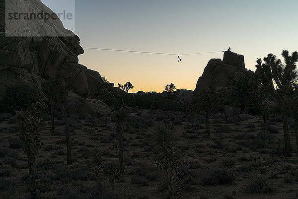 Niedrigwinkelansicht der Silhouette einer Person  die sich bei klarem Himmel über Berge schlängelt