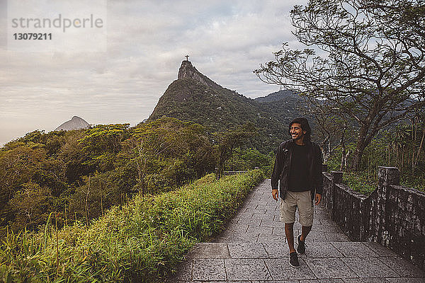 Lächelnder Mann bewegt sich auf Stufen gegen den Berg in Rio de Janeiro