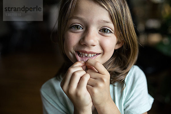 Porträt eines glücklichen Mädchens mit Zahnlücke zu Hause