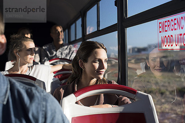 Fahrgäste  die während der Fahrt im Reisebus durch das Fenster schauen