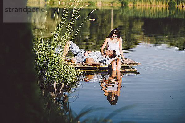Freund liegt auf dem Schoß der Freundin am See im Park