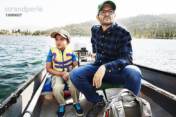 Vater und Sohn fahren in einem Motorboot auf dem See