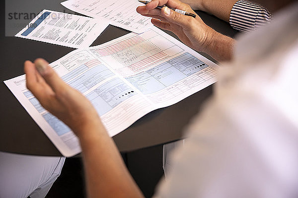 Ausgeschnittenes Bild eines Arztes  der dem Patienten in der Klinik medizinische Unterlagen erklärt