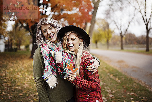 Lächelnde weibliche Unholde stehen im Herbst auf dem Feld