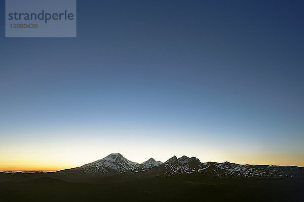 Landschaftliche Ansicht von Bergen gegen blauen Himmel bei Sonnenuntergang