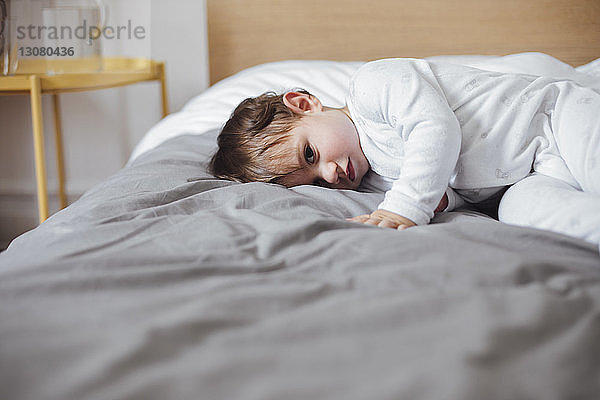 Porträt eines süßen kleinen Jungen  der zu Hause im Bett liegt