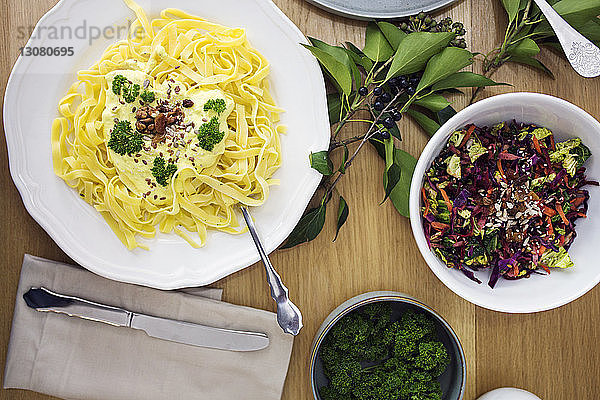 Draufsicht auf Spaghetti-Nudeln mit Salat  die auf dem Tisch serviert werden