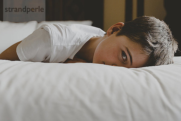 Porträt eines Jungen  der sich zu Hause auf dem Bett ausruht