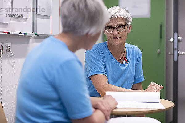 Ärzte diskutieren im Krankenhaus über Krankenakten