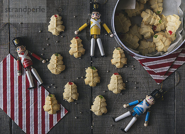 Draufsicht auf Figuren mit Keksen auf Holztisch zu Weihnachten
