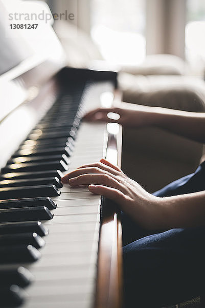 Ausgeschnittenes Bild eines Jungen  der zu Hause Klavier spielt