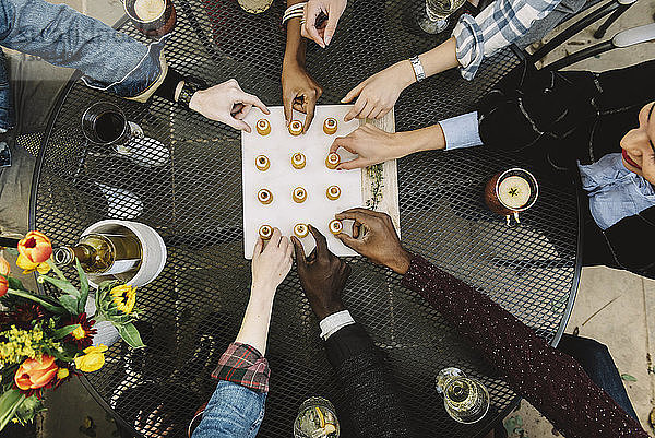 Ausgeschnittenes Bild Freunde beim Aperitifessen am Tisch im Hinterhof