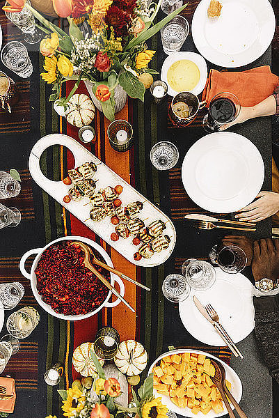 Ausgeschnittenes Bild von Freunden beim Essen mit Getränken am Tisch