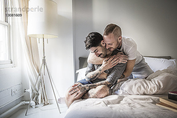Liebevolles homosexuelles Paar zu Hause im Bett