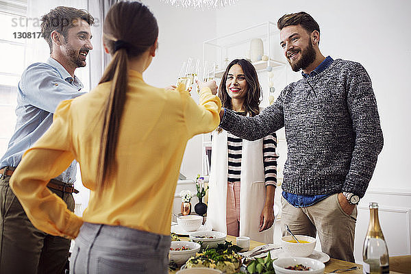 Glückliche Freunde stoßen in der Lunch-Party feierlich an