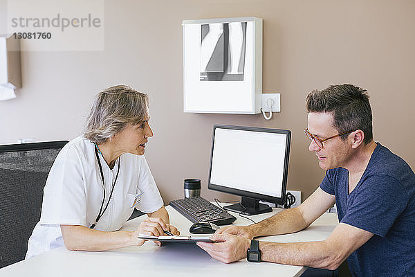 Ärztin diskutiert mit Patientin im Krankenhaus
