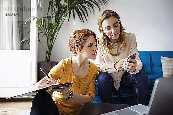Geschäftsfrauen planen  während sie im kreativen Büro sitzen