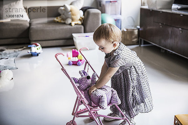 Mädchen spielt zu Hause im Wohnzimmer mit Plüschspielzeug