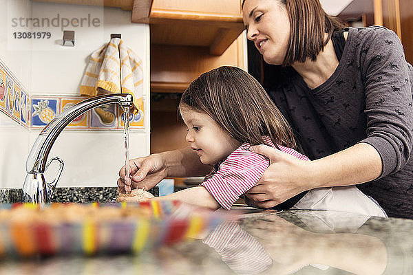 Mutter wäscht Mädchen in der Küche die Hände