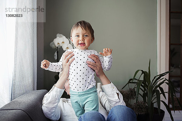 Porträt eines glücklichen kleinen Mädchens mit Großmutter  das zu Hause auf dem Sofa sitzt
