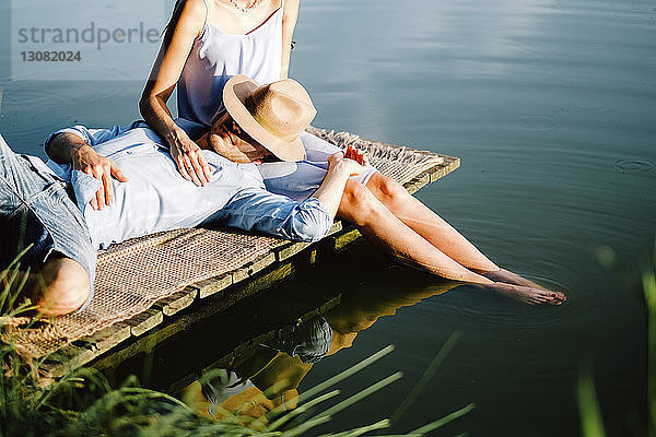 Freund entspannt sich auf dem Schoß der Freundin am See im Park