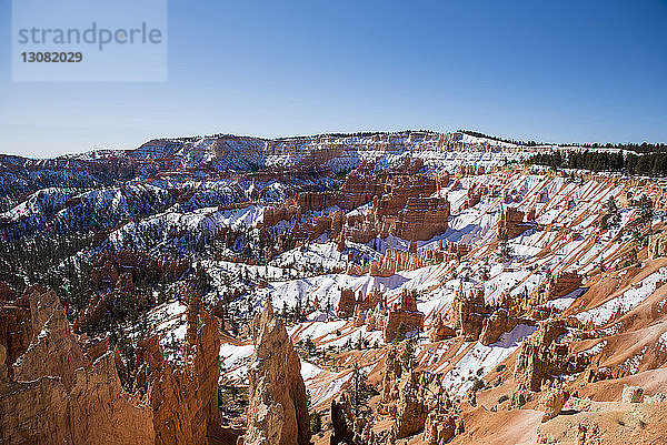 Landschaftliche Ansicht von Felsformationen in der Schneewüste bei klarem Himmel im Winter