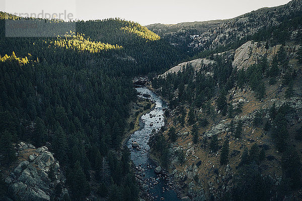 Hochwinkelansicht eines Flusses inmitten von Bergen im Wald