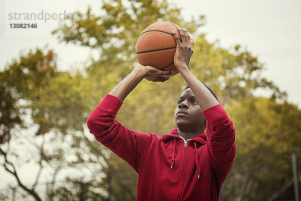 Student hält Basketball beim Spielen auf dem Platz