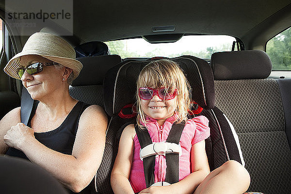 Großmutter und Enkelin im Auto sitzend