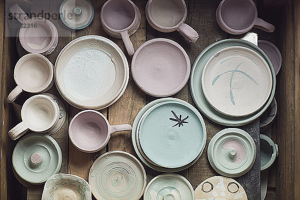 Draufsicht auf verschiedene Keramiken auf dem Tisch in der Werkstatt
