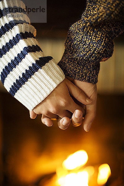 Ausgeschnittenes Bild eines Paares  das sich an der Feuerstelle an den Händen hält
