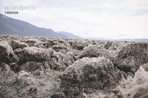 Texturierte Felsen gegen Berge und Himmel im Death Valley National Park