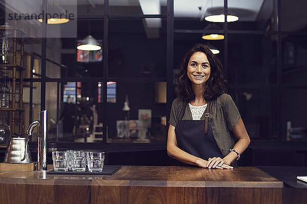 Porträt einer glücklichen Besitzerin im Café stehend