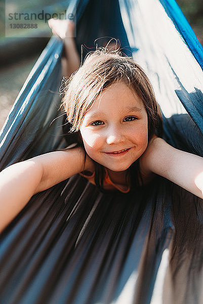 Porträt eines glücklichen Mädchens in der Hängematte liegend