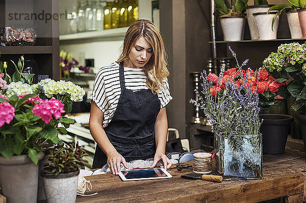 Besitzer benutzt Tablet-Computer im Blumenladen