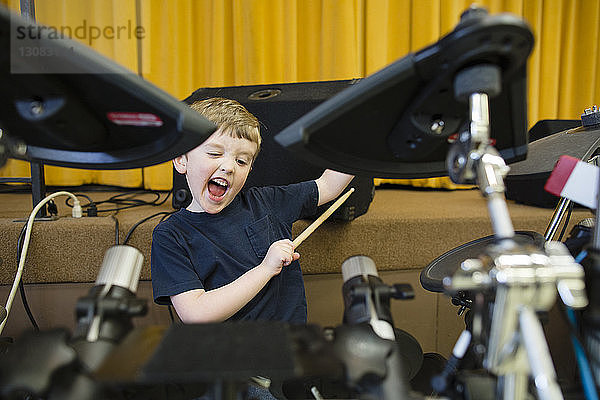 Verspielter Junge spielt Schlagzeug in der Grace Baptist Church