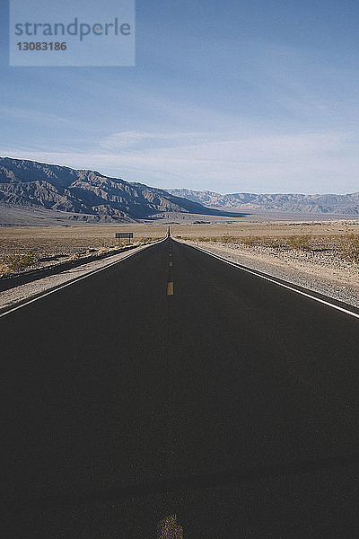 Landstraße inmitten der Wüste gegen Berge und Himmel im Death Valley National Park