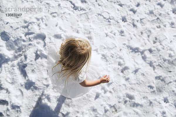 Draufsicht auf ein Mädchen  das auf einem schneebedeckten Feld läuft