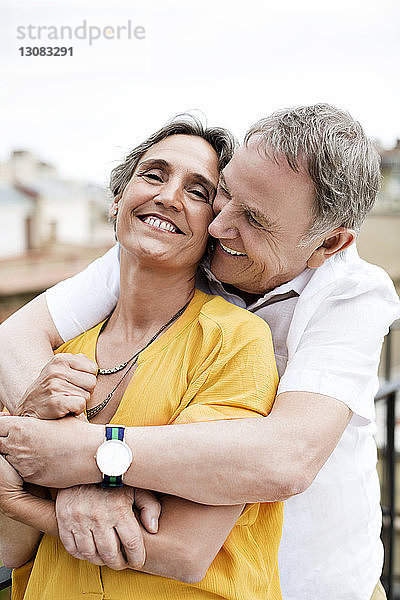 Liebender älterer Mann umarmt Frau auf Terrasse