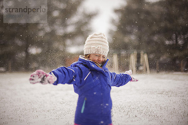 Glückliches Mädchen genießt Schnee