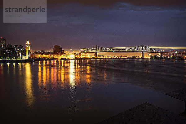 Beleuchtete Brücke über den Fluss bei Nacht