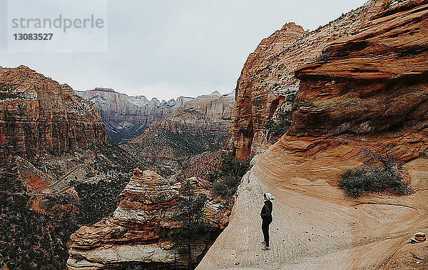 Wanderin in voller Länge auf einer Felsformation im Zion-Nationalpark stehend