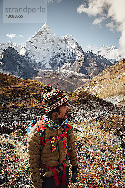 Wanderer in warmer Kleidung steht auf Berg gegen Himmel im Sagarmatha-Nationalpark