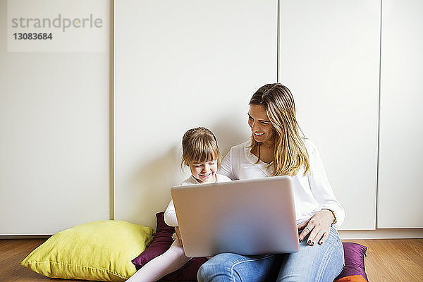 Glückliche Mutter und Tochter mit Laptop zu Hause