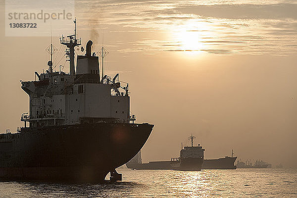 Frachtschiff bei Sonnenuntergang auf See