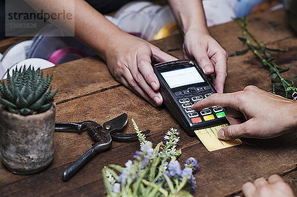 Ausgeschnittenes Bild eines Kunden  der mit Kreditkarte bezahlt